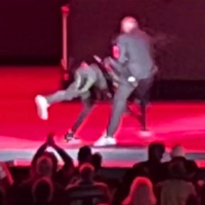 A man, Comedian Dave Chappelle being attacked by another man