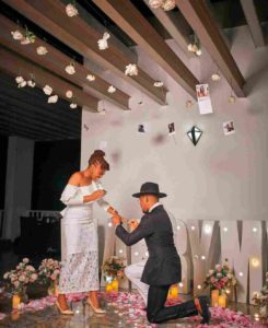 A man kneeling to put a ring in a woman's finger